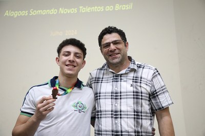 Gabriel de Melo Martins, com o pai, para receber medalha de bronze da OBMEP