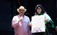 Fábio Pascola entrega à vice-reitora uma tela pintada por Hermeto