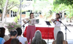 Professora Ziliane Teixeira, na flauta, e Iannara Farias, no violino, se apresentaram na cerimônia de instalação do banco vermelho
